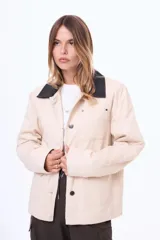 Campera de gabardina color verde militar con cuello de cuero sintético negro, cierre frontal con botones metálicos y bolsillos frontales con solapa.