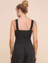 Top crop negro de corte ajustado y estructurado, con escote corazón, tirantes anchos y textura acanalada fina con costuras estilo corsé.