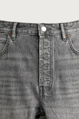 Jeans regular fit de mezclilla negra con efecto lavado, corte recto y tiro medio. Cuenta con diseño de cinco bolsillos y cierre frontal con cremallera y botón.