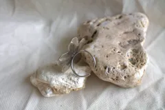 Anillo plateado con forma de flor de hibisco y textura martillada.