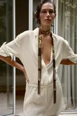 Mono corto camisero de mezcla de lyocell con estampado de rayas finas, cuello solapa, manga larga y cierre frontal con botones. Presenta cintura elástica y detalles de encaje en el bajo.