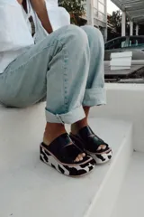 Sandalias negras con plataforma y estampado animal print de vaca.