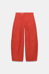 Pantalón cargo oversize de tiro medio color rojo, con bolsillos laterales y de plastrón, y lazadas ajustables en la cintura.