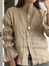 Collar largo con cadena de eslabones gruesos en bronce y dije central con forma de sol con centro rectangular de nácar.