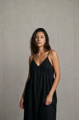 Vestido midi negro con tirantes finos, escote en V y corte fluido con frunces bajo el busto.