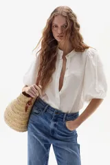 Camisa de lino color blanco, con cuello mao, mangas abullonadas hasta el codo y cierre frontal con botones.