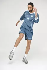 Short deportivo azul con finas rayas verticales blancas, cintura elástica y logo estampado en la pierna.