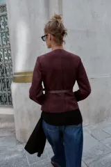 Blazer de cuello redondo y manga larga, confeccionado en tejido efecto ante. Presenta cierre frontal con botones, bolsillos con tapeta en el pecho y cinturón ajustable en la cintura.