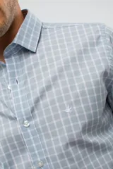 Camisa de manga larga con diseño de cuadros en tonos azules, blancos y negros. Presenta cuello clásico, cierre frontal con botones y logo bordado en el pecho. Corte semi slim.