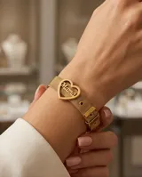 Pulsera de acero con baño de oro, compuesta por una malla metálica ajustable tipo cinturón y un dije central en forma de corazón con la palabra 'Mamá' calada en su interior.