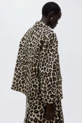 Chaqueta oversized con estampado de leopardo, cuello camisero, cierre de botones forrados y bolsillos delanteros ribeteados con solapa.