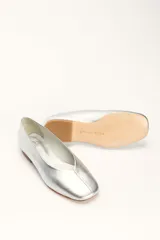 Chatas planas de cuero color plateado metálico, con punta cuadrada y un pequeño tacón bajo de madera.