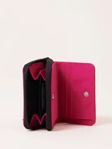 Billetera de nylon color verde esmeralda con cierre perimetral y parche de goma negro con logo grabado en el frente.