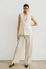 Pantalón recto color crema de lino con costuras laterales en negro.