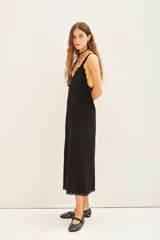 Vestido midi negro de viscosa con breteles finos de encaje y detalle de tachas termo adhesivas en el escote y ruedo.