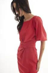 Vestido corto de lino color rojo, con mangas globo y escote redondo. Presenta un corte entallado en la cintura con un lazo ajustable que permite entallar la prenda.