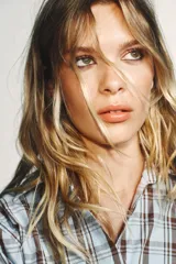 Camisa de algodón con estampado a cuadros en tonos celeste y marrón. Presenta cuello solapa, escote pico y diseño cruzado con lazada frontal.