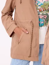 Rompevientos negro con capucha ajustable mediante cordones, cierre frontal de cremallera y ajuste en la cintura con cordón. Presenta logo de la marca bordado en el pecho y puños con detalle de botón.