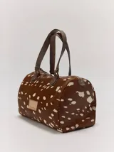 Cartera tipo baúl Margara Shaw confeccionada en 100% cuero con estampado animal print de serpiente, asas de mano marrones y cierre superior.