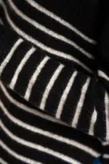 Sweater de tejido de punto color beige melange, con cuello redondo y mangas largas. Presenta rayas horizontales en tonos verde oliva, lila, marrón, naranja y rosado.