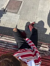 Pantalón de jean negro de tiro alto y corte recto, con detalles de roturas en las rodillas.