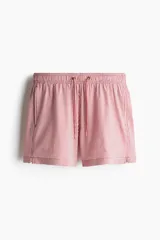 Short de baño de sirsaca con diseño a rayas verticales en color rojo y blanco. Cuenta con cintura elástica con cordón de ajuste, bolsillos laterales, bolsillo trasero con cierre y aberturas laterales en el ruedo.