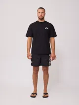 Remera blanca de hombre con logo de la marca Rusty estampado en el pecho y diseño a cuadros en la parte inferior trasera.