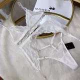 Set de lencería de cuatro piezas compuesto por bralette de encaje y microtul, tanga regulable, portaligas y ligas. Diseño con transparencias y detalles de encaje.