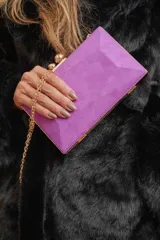Clutch de gamuza color obispo (morado) con bordes dorados y cadena dorada.