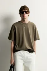 Remera de corte holgado color gris oscuro, con cuello redondo y mangas cortas. Confeccionada en tejido suave con mezcla de modal.