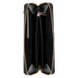 Billetera Guess modelo Coleen de color negro, confeccionada en material sintético con cierre perimetral y tira de muñeca desmontable. Presenta el logo de la marca y la letra 'G' metálica en tono dorado en la parte frontal.