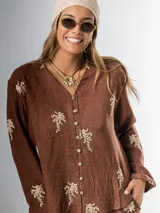 Conjunto de camisa y pantalón marrón chocolate con bordados en hilo crudo. El pantalón lleva elástico en la cintura.