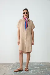 Pañuelo liviano y translúcido de diseño romboidal, con estampado inspirado en un atardecer uruguayo en tonos rosa, rojo y azul, ideal para usar atado al cuello.