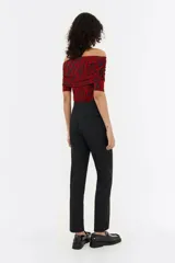 Pantalón negro de lana fría, corte ajustado, con cierre frontal de botón y cremallera, bolsillos laterales y cremallera invisible en el bajo de la pierna.