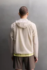 Chaqueta cortavientos de Zara Athleticz color beige, de tejido técnico ligero y elástico, con cuello subido, capucha, cierre frontal de cremallera y bolsillos laterales con cierre oculto.