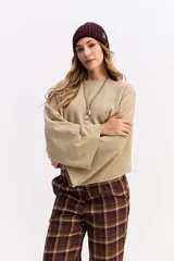 Blusa de corte relajado y fit holgado, con mangas largas amplias y textura sutil. Presenta un diseño minimalista con caída suave.