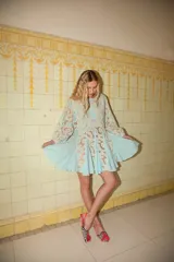 Vestido corto celeste con paneles de encaje y bordados decorativos, mangas abullonadas y falda evasé con vuelo.