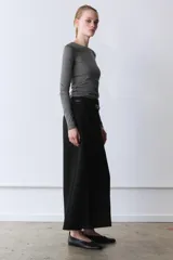 Pantalón culotte negro de tiro medio con trabillas y cinturón fino efecto piel con hebilla metálica. Presenta raya planchada y cierre de cremallera oculta en la costura.