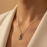 Conjunto compuesto por una cadena de eslabones finos y un dije circular con relieve de un ángel querubín, fabricado en plata 925.