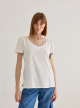 Remera de algodón con escote en V, mangas cortas con frunces en los hombros y detalle de bolsillo frontal con costuras a la vista.