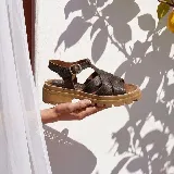 Sandalias de cuero vacuno negro con textura símil cocodrilo, diseño de tiras cruzadas, suela track de goma y hebilla metálica de ajuste en el tobillo.
