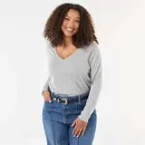 Remera de punto color gris, con cuello en V y mangas largas.