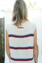Vestido midi tejido en hilo de algodón, sin mangas y con escote redondo. Presenta un diseño de rayas horizontales en tonos beige, azul y rojo.