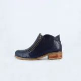 Botín azul con textura símil reptil, cierre lateral con cremallera y taco bajo de madera.