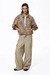 Campera oversized de sarga con estampado de leopardo, cuello camisero, cierre frontal, bolsillos laterales ribeteados y puños elásticos.
