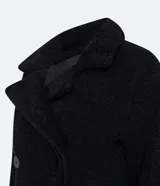 Campera alargada de sherpa color verde manzana, con cuello solapa, cierre cruzado con botones y bolsillos delanteros.