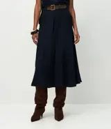 Pollera midi de corte fluido confeccionada en crepé, con pliegues delanteros y cinturón decorativo integrado con hebilla cuadrada. Presenta un diseño minimalista y elegante con cierre discreto.