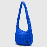 Tote bag color negro con diseño acolchado y voluminoso. Cuenta con un compartimento principal con cierre y una correa de hombro integrada.