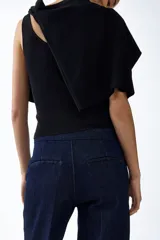Jean de denim azul oscuro con tiro alto y corte acampanado, confeccionado con algodón elástico. Presenta bolsillos laterales al bies y cierre frontal oculto.