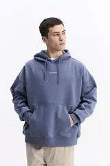 Canguro con capucha de calce oversize, color azul grisáceo. Presenta un estampado gráfico en la espalda con la inscripción 'UNDERRATED vision' y el logo de la marca Mistral. Confeccionado en tejido de algodón y poliéster.